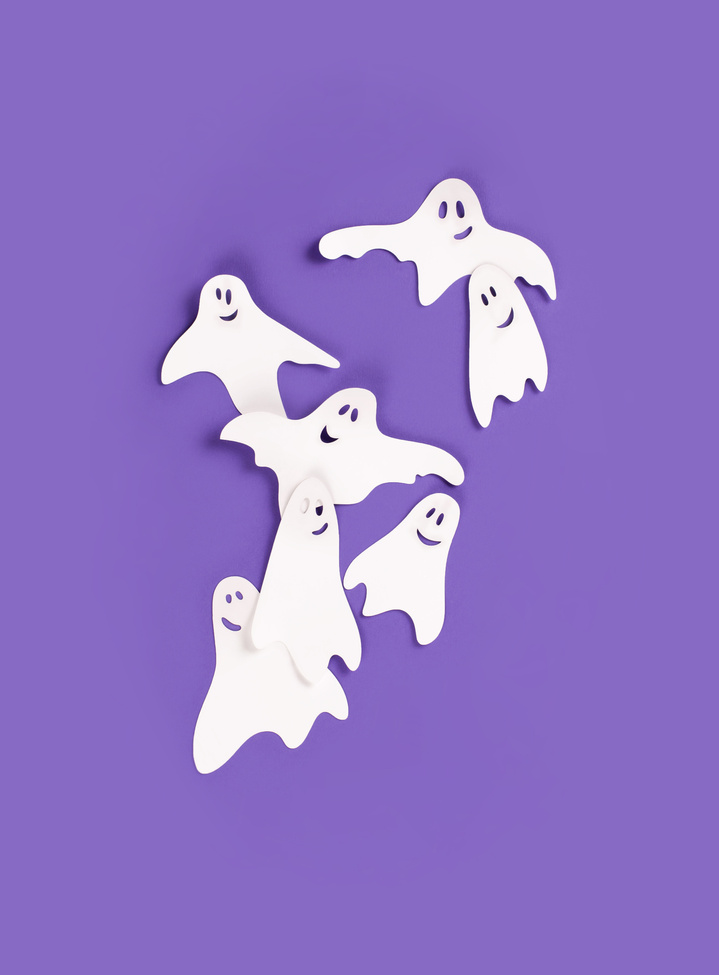 Halloween ghosts on purple background.
